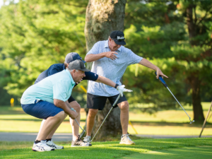 Three men playing golf