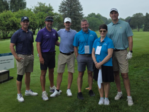 Several people standing on a golf course